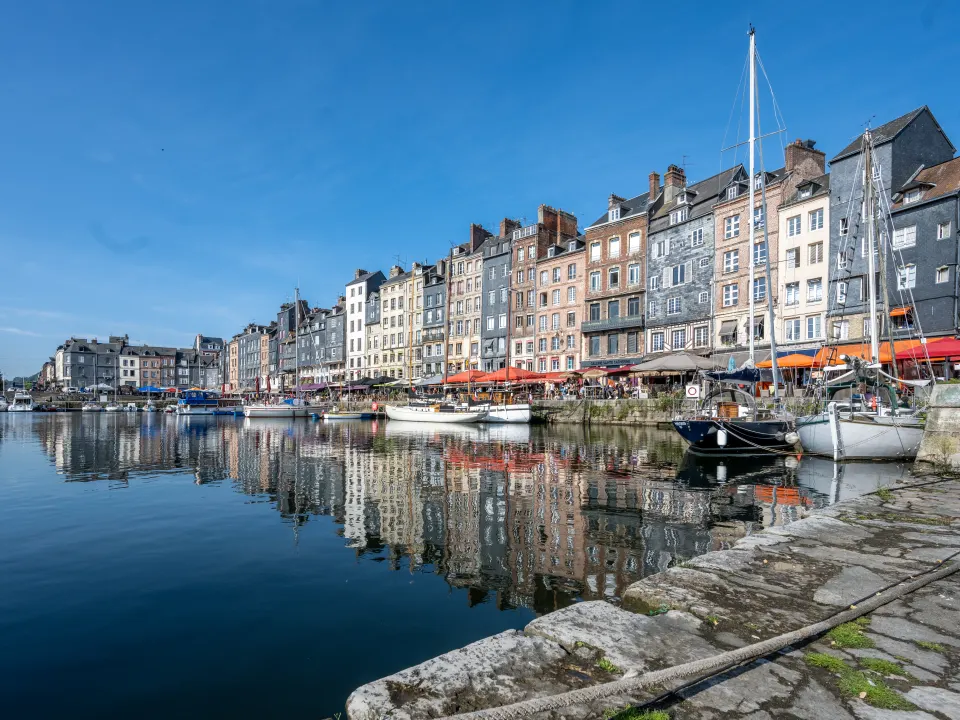 Les maisons étroites et les bateaux du Vieux-Bassin d'Honfleur sous un ciel bleu