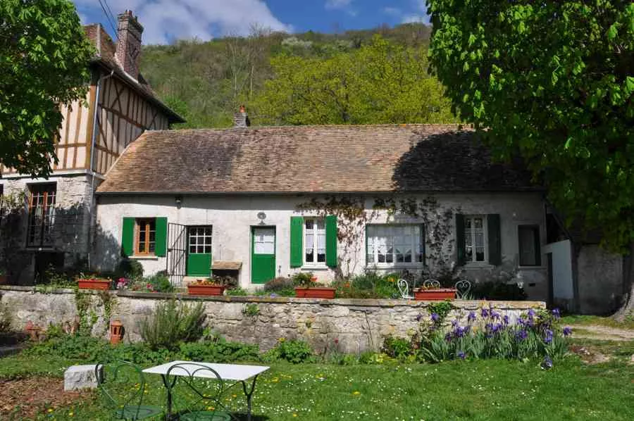 L'Hermitage vu du jardin : l'aile des chambres aux volets verts, devant la colline